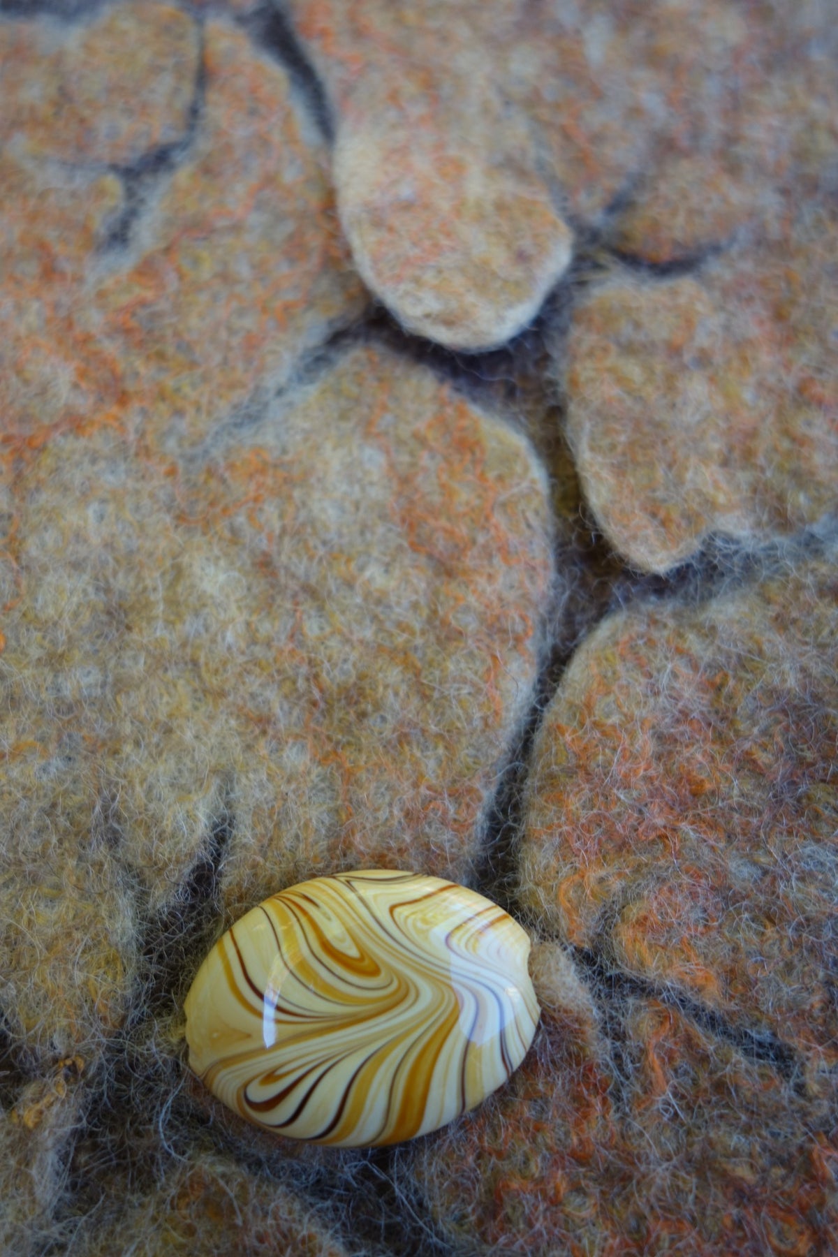 Close-up of sculptural cracked-stone texture and decorative button on Cracked bag