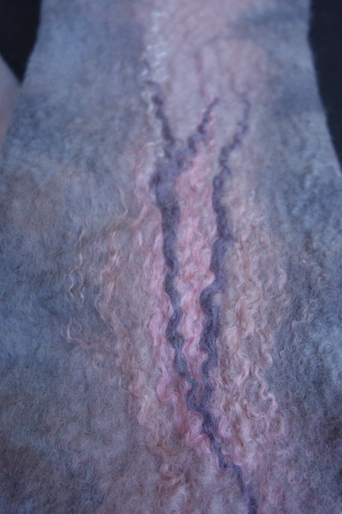 Close-up of pink and lavender fiber detail on hand-felted fingerless gloves