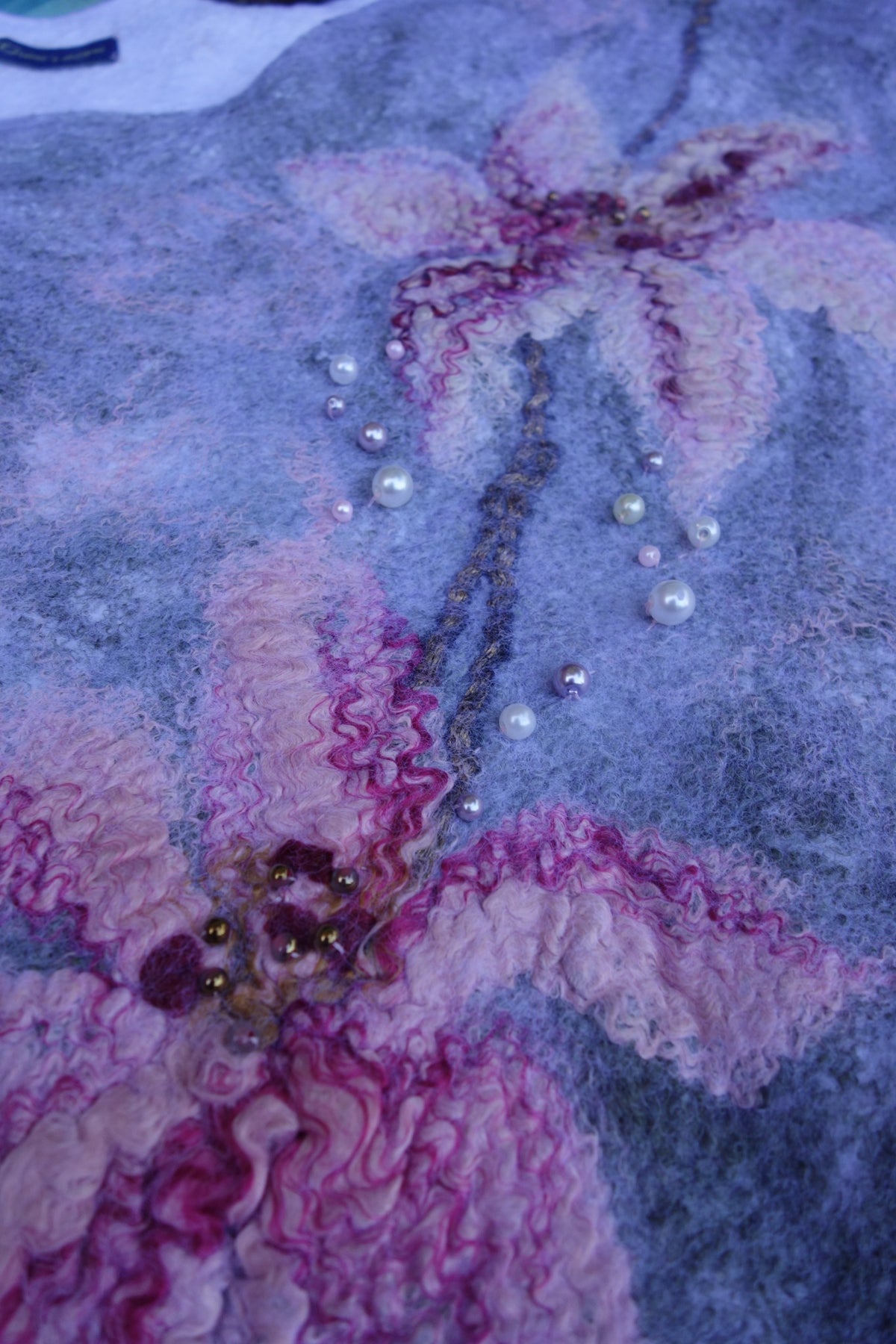 Close-up of beaded felted lily details on Lilies in the Morning Fog poncho