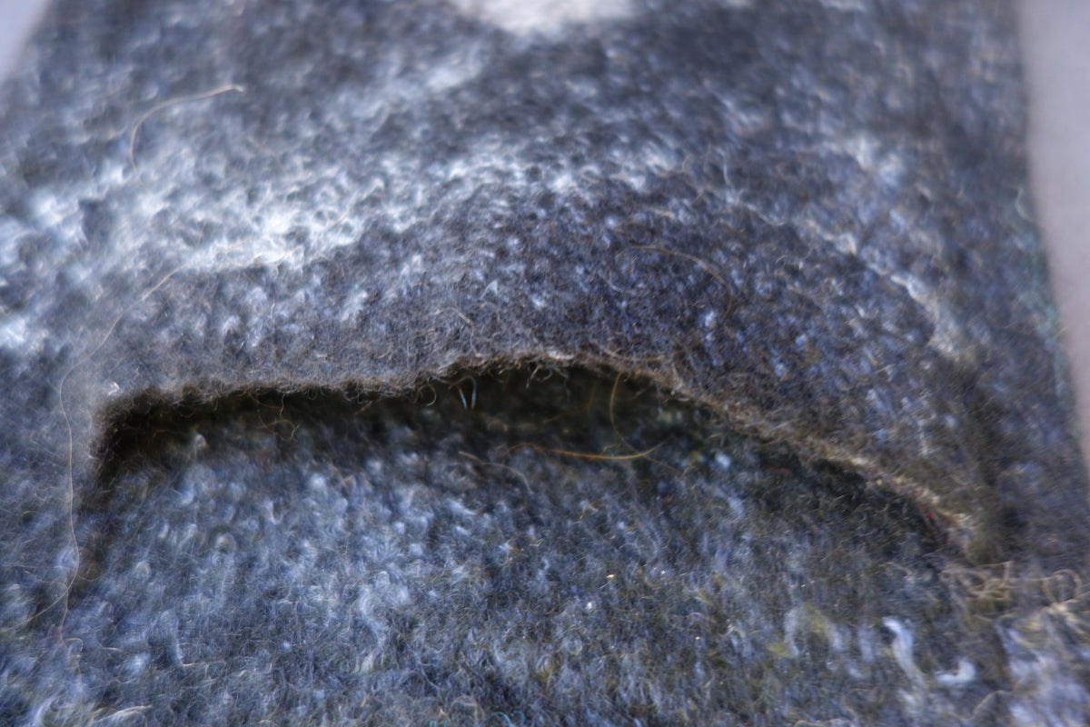 Close-up of back phone pocket on hand-felted crossbody bag