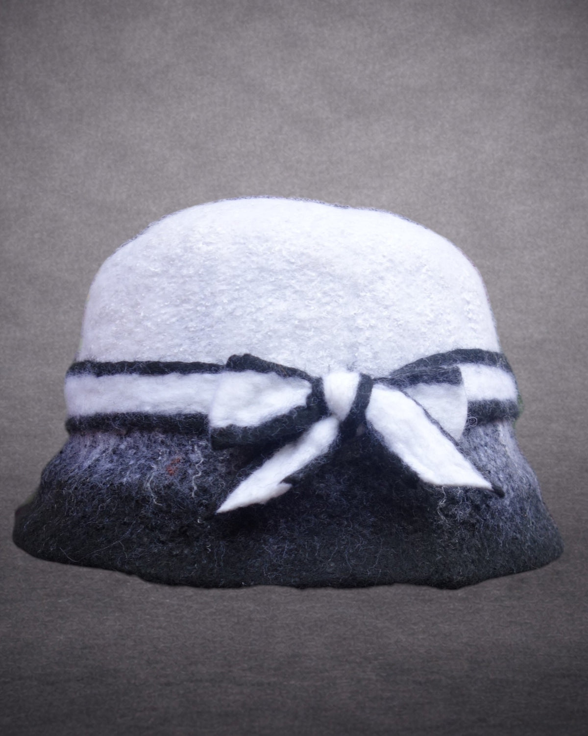 Black and white hand-felted merino wool hat with bow front view