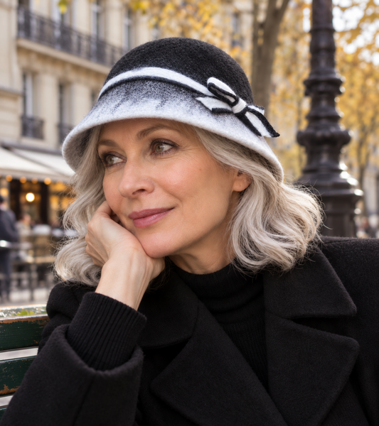 Black and white soft hand-felted bucket hat with bow worn outdoors
