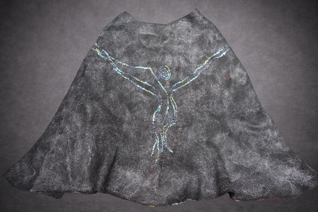 Fire in the Night poncho laid flat, reverse side in black grey blue and green