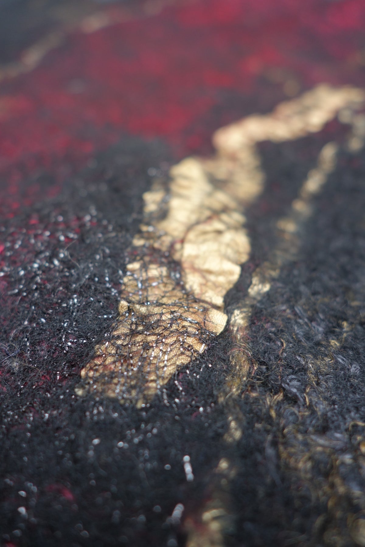 Close-up of nuno-felted silk and textured fibers on Fire in the Night poncho