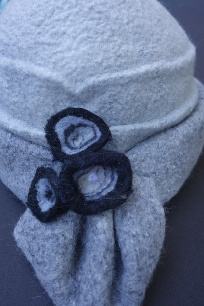Close-up of charcoal felted flower details on silver grey hat