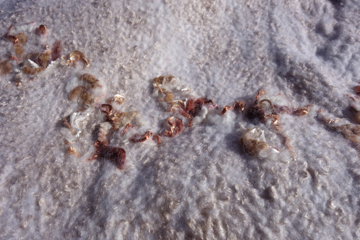 Close-up of caramel-toned fiber detailing on Ivory Sands poncho