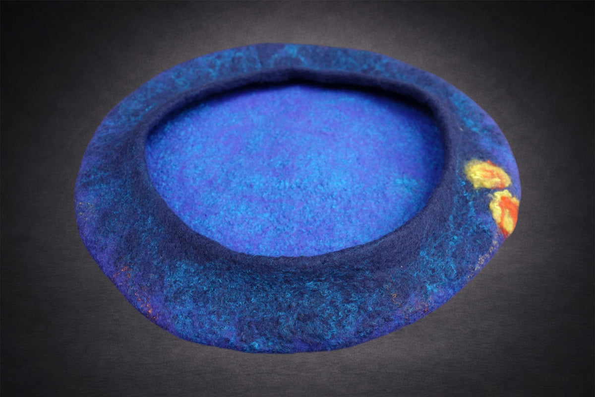 Inside view of blue hand-felted beret showing soft construction and floral accents