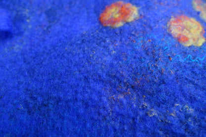 Close-up of blue felted beret texture with multicolor fibers and floral details