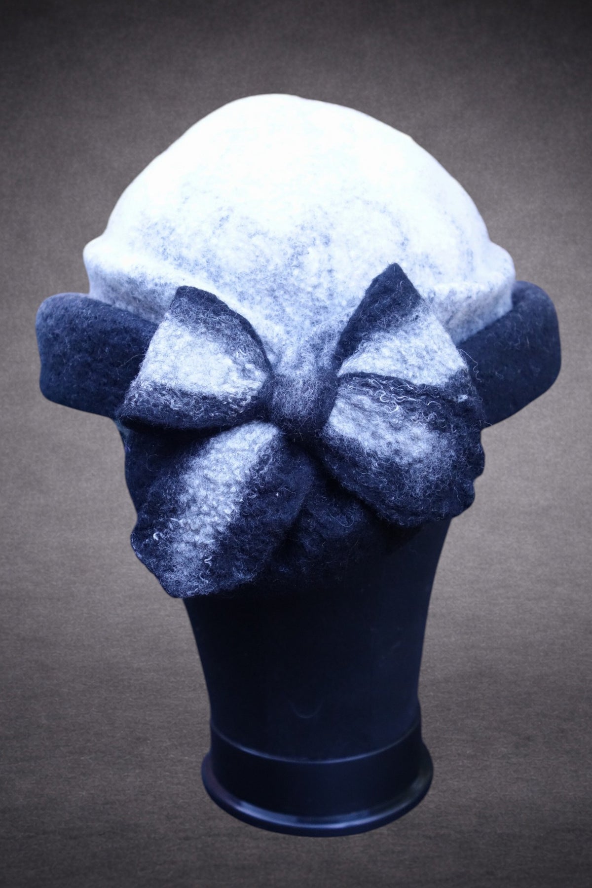 Black and ivory asymmetric felted hat with French bow, front mannequin view